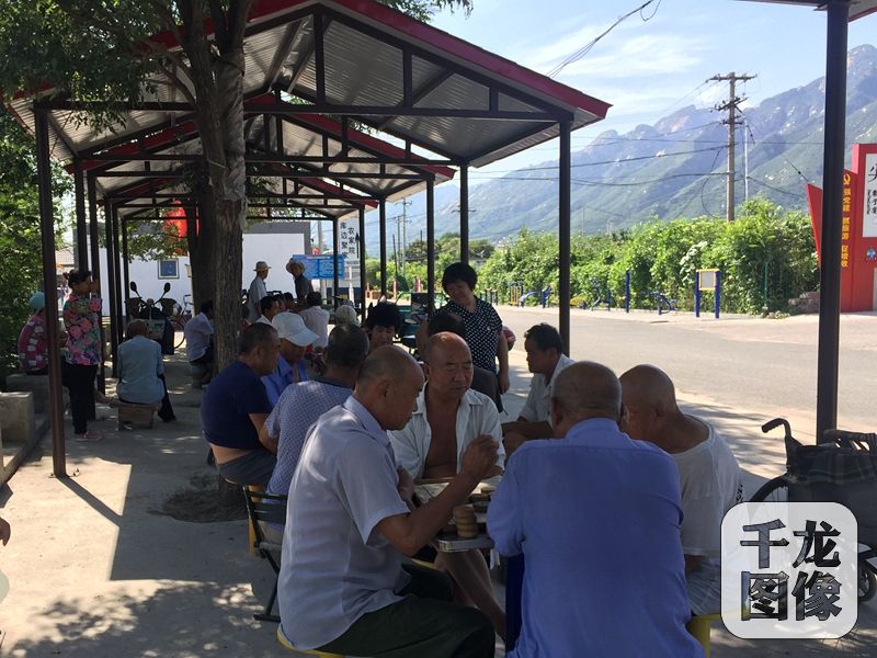 現在，劉大爺吃過午飯，就會去村口新修的休閑區跟老伙伴兒們玩牌、下棋，偶爾也會用路旁新安裝的健身器材鍛煉身體。圖為午后村口休閑區內，村民們正在下棋。千龍網記者 薄晨棣攝