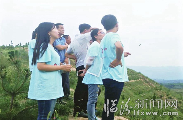 同學們走進田間地頭了解村里情況。